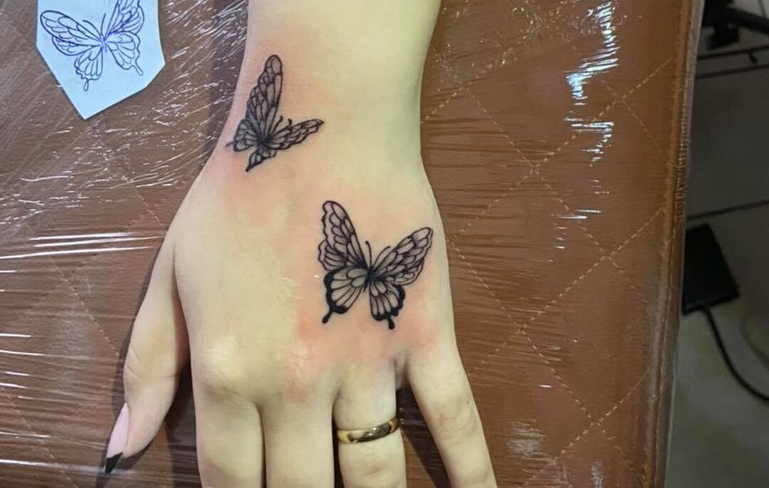 tatuagem de borboleta na mão feminina